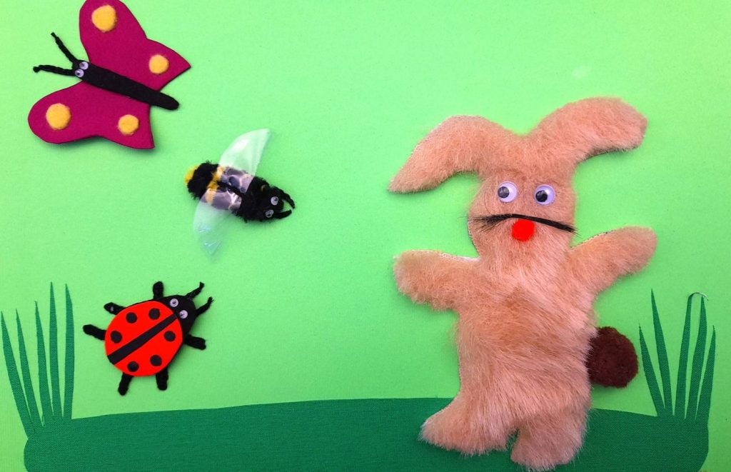 Na fotografiji je taktilna ilustracija iz slikovnice "Plesna haljina žutog maslačka", koju su prema priči Sunčane Škrinjarić izradile Natalija Dragoja i Hela Čičko. Na njoj je zeko na livadi s leptirom, bubamarom i pčelom.